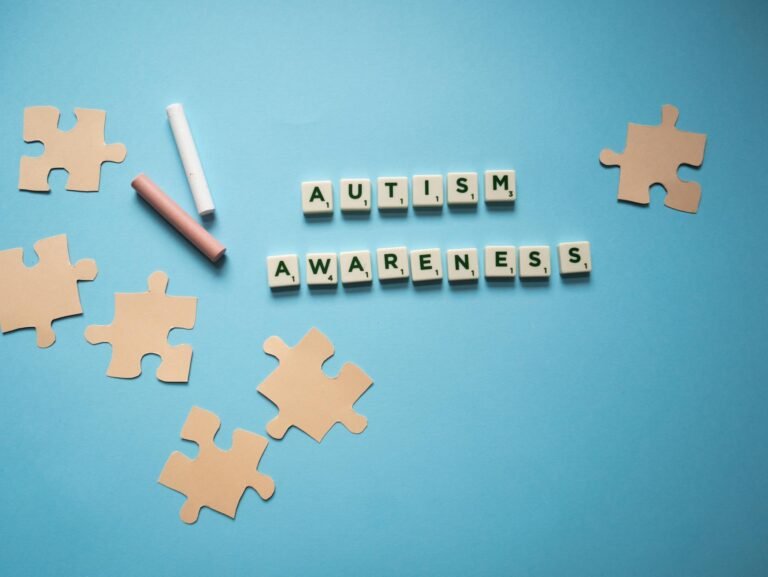 Creative autism awareness concept with puzzle pieces on a blue background.